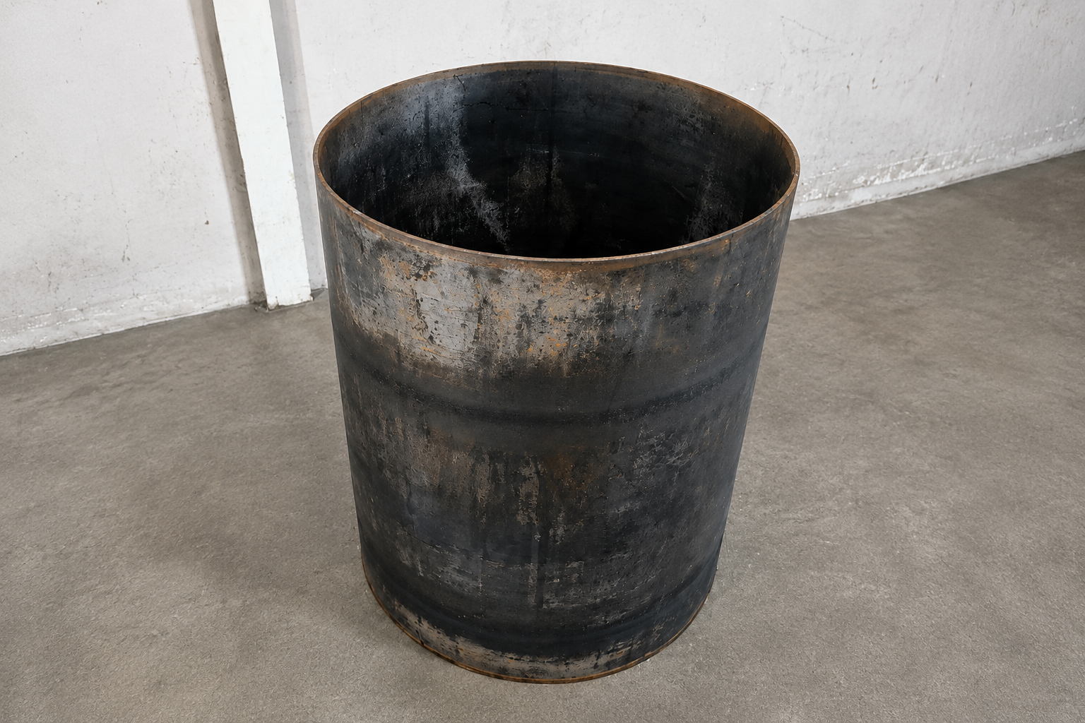 Finished steel cylinder standing on a workshop floor after plate rolling