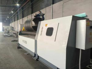 W12-12x2500 four-roll plate rolling machine forming a cylinder with an operator at the machine