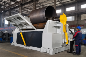 Operator running a plate rolling machine that is forming a large steel cylinder