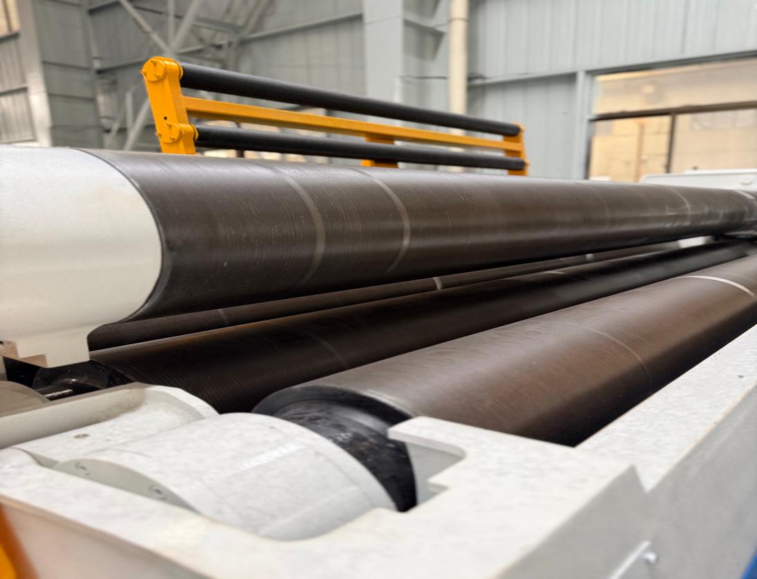 Close-up of hardened plate rolling machine rolls in a white machine frame