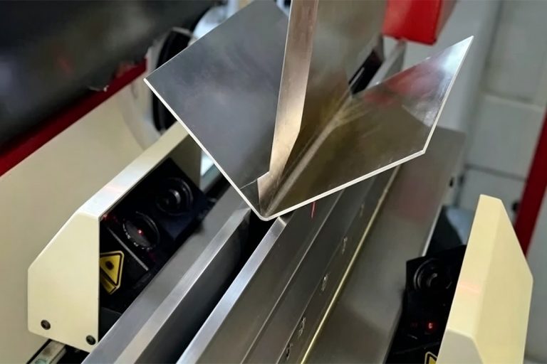 Sheet metal bending in progress between the punch and die of a press brake