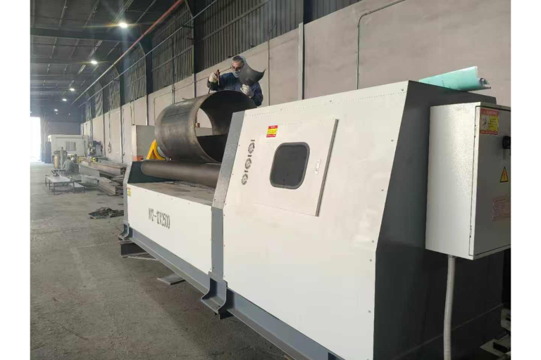 W12-12x2500 four-roll plate rolling machine forming a cylinder with an operator at the machine